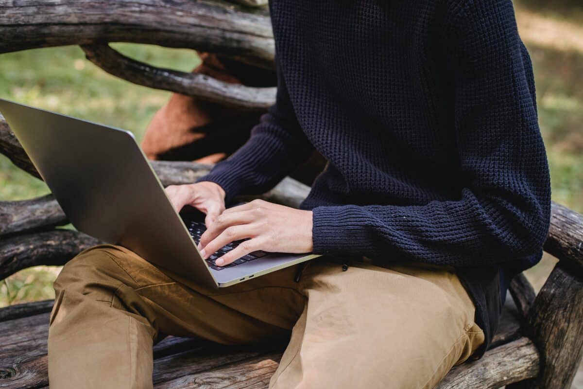 un homme sur son PC sur un banc