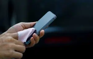 Handy reinigen: Smartphone wird mit Mikrofasertuch abgerieben