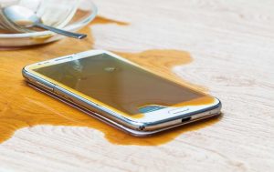 Handy-Reparatur: Smartphone liegt in einer Kaffeepfütze